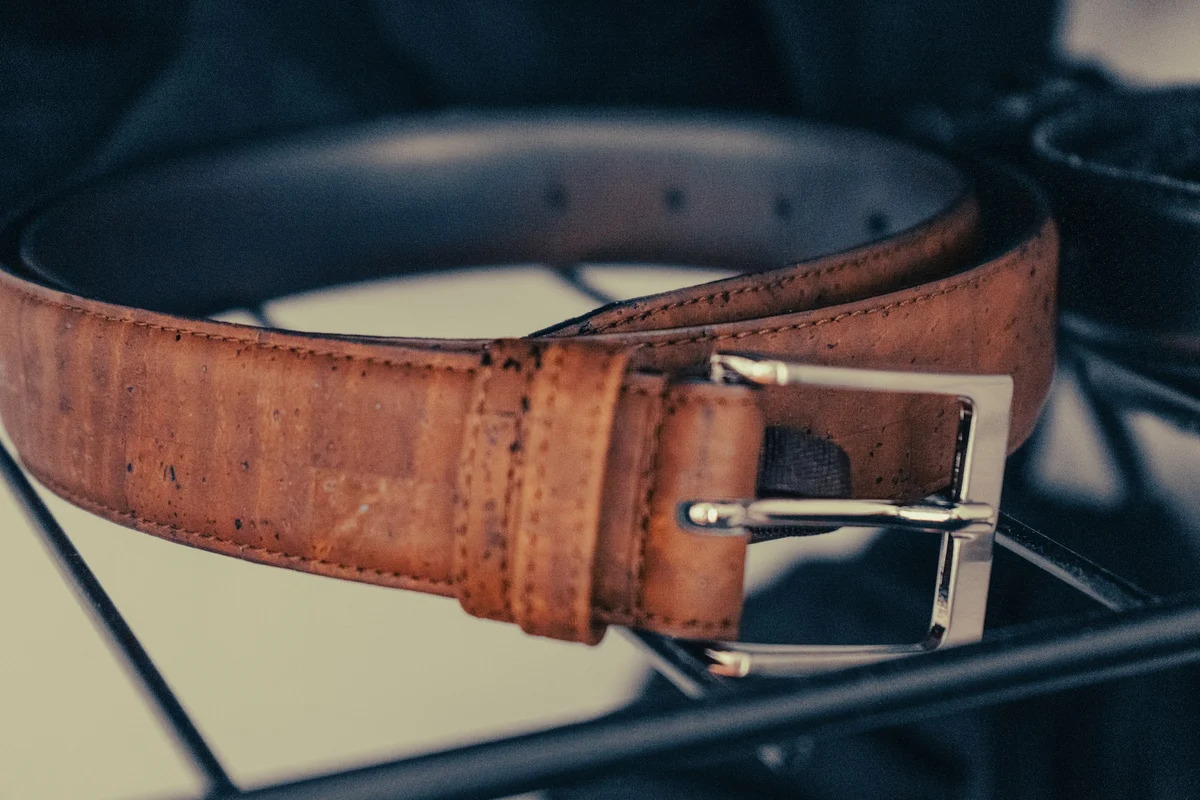 Close-up of a brown leather belt buckle showing its metal finish