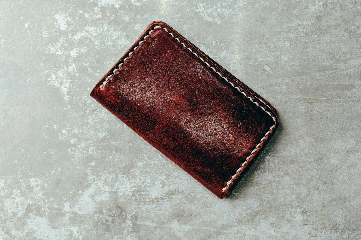 Brown leather wallet on a light surface during cleaning and conditioning